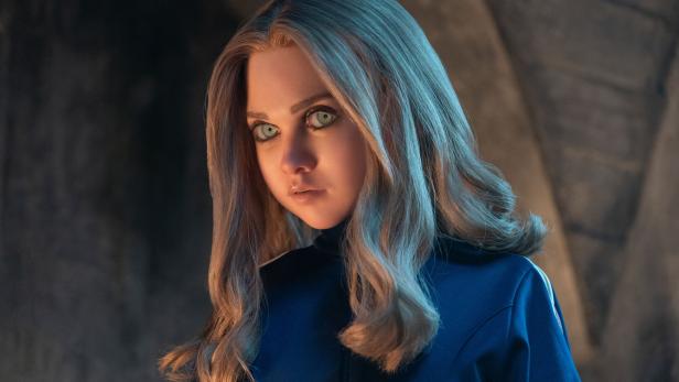 Nahaufnahme der unheimlichen Puppe M3GAN mit blauen Augen und blonden Haaren.