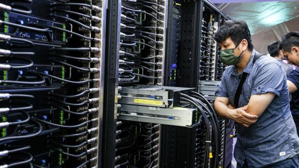 Techniker vor einem Server Rack in einem Rechenzentrum.