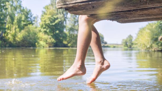 Female legs splashing in the pool of water