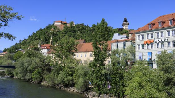 Blick auf den Grazer Uhrturm mit Mur im Vordergrund