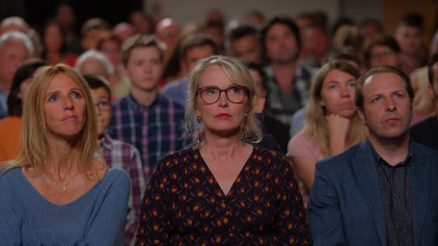 Zuschauer sitzen aufmerksam bei einer Veranstaltung.