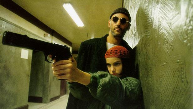 Mathilda hält eine Waffe, während Léon hinter ihr steht.