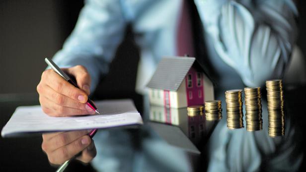 Real estate agent is holding a house model Real estate agent is holding a house model