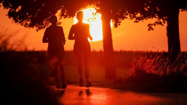 Sommer in Baden-Württemberg Zwei Frauen laufen bei aufgehender Sonne