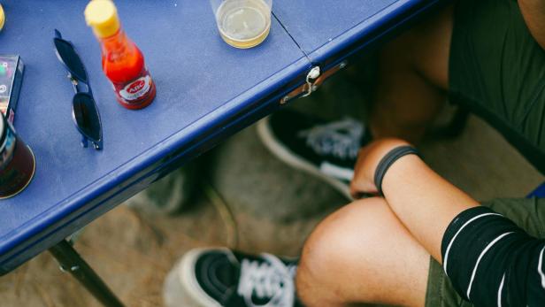 Person sitzt vor blauem Tisch
