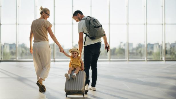 Junge Familie mit Kind am Flughafen.