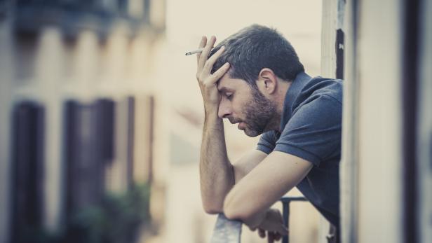 young man at balcony in depression suffering emotional crisis