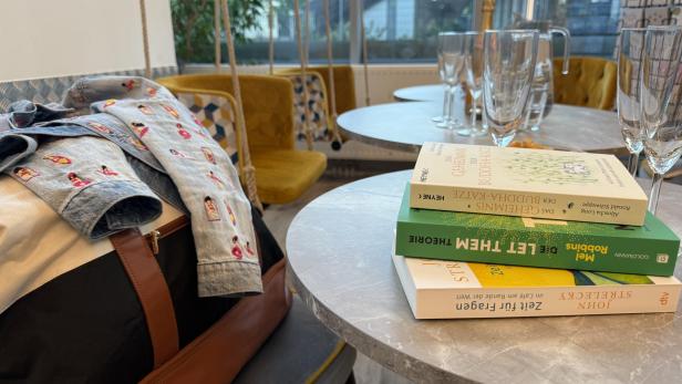 Ein Stapel Bücher steht auf einem Tisch.