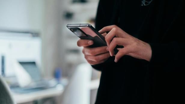 Mann hält Smartphone in Händen