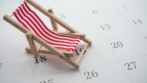 Red beach chair on white blank calendar background copy space.