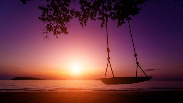 Sonnenuntergang am Meer mit einer Schaukel