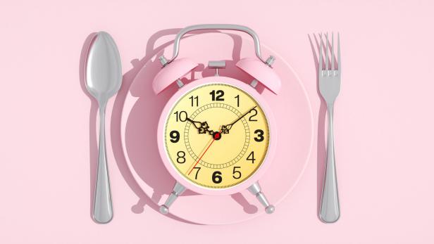 Mahl-Zeit! Die innere Uhr bittet zu Tisch Wecker liegt auf einem Essteller, link und recht Löffel und Gabel