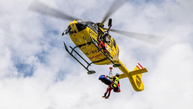 Ein gelber ÖAMTC-Hubschrauber bei einer Rettungsaktion.