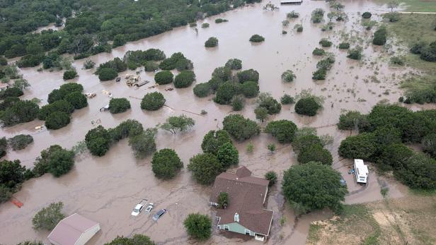 Houses and cars are partially submerged in flood waters in an aerial view near Kerrville Houses and cars are partially submerged in flood waters in an aerial view near Kerrville