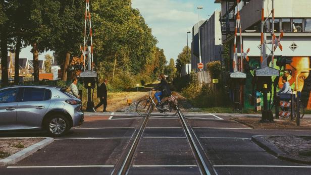 Frau auf Fahrrad überquert Zugschienen