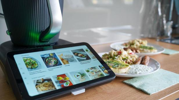 Der neue Thermomix 7 steht in der Küche auf der Arbeitsfläche und daneben steht ein Teller mit fertig zubereiteten Speisen angerichtet.