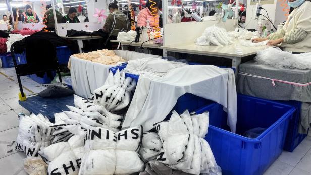 FILE PHOTO: Workers work at a production line manufacturing clothing for Shein at a factory in Guangzhou