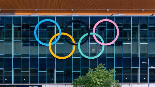 Die olympischen Ringe hängen an einem Gebäude in Innsbruck.
