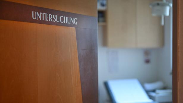 Eine Tür mit der Aufschrift „Untersuchung“ führt in einen Untersuchungsraum.