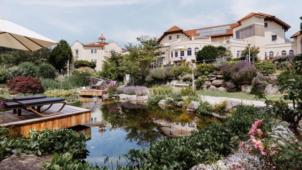 Ein schönes Haus mit großer, begrünter Gartenanlage und einem Teich.