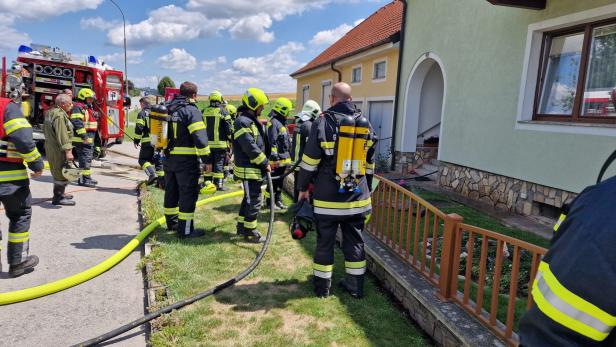 Feuerwehrleute im Einsatz bei einem Haus