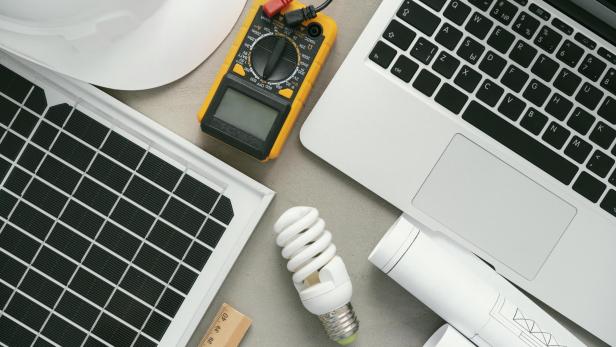 Auf einem Tisch liegen verschiedene elektrische Werkzeuge und Geräte.
