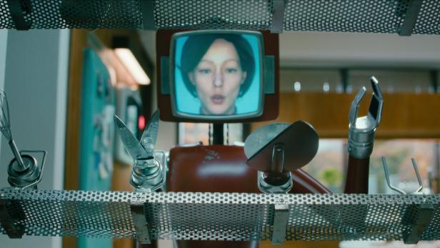 Ein Küchenroboter mit einem Bildschirm, der das Gesicht einer Frau zeigt, aus der Netflix-Serie „Cassandra: Limited Series“.