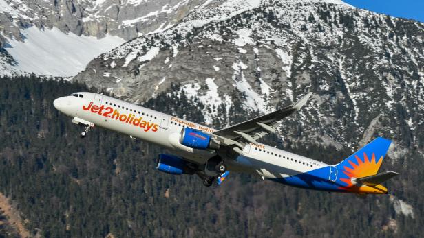 Jet2holidays-Flugzeug Blau-weißes Flugzeug mit Jet2holidays-Werbeaufschrift hebt vor einer Berglandschaft ab