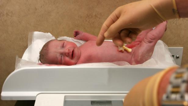 New born baby being weighed on a scale…