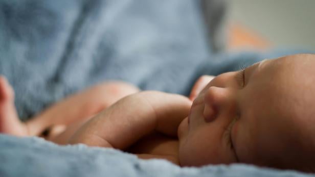 Baby liegt auf blauer Decke