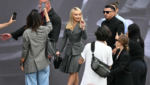 Sabrina Carpenter in Dior bei der Fashion Week in Paris beweist: Knielange Faltenröcke müssen nichts mit Schulmädchen-Uniformen zu tun haben.