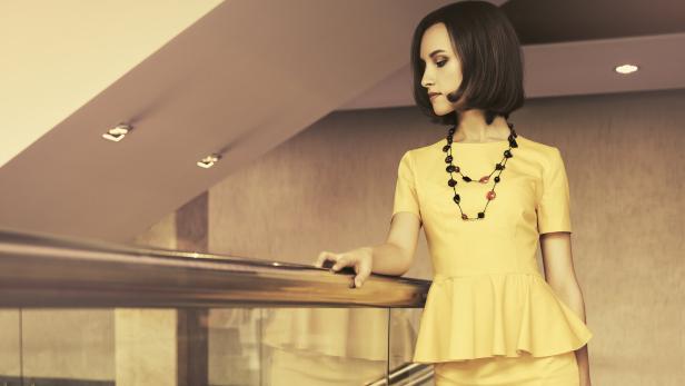 Eine junge, modische Geschäftsfrau in einem Bürogebäude.