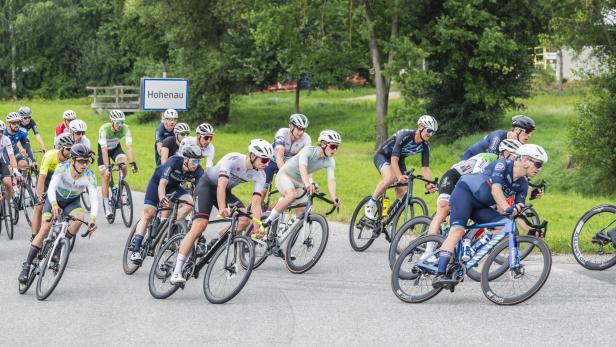 Mehrere Radfahren legen sich in eine Kurve.