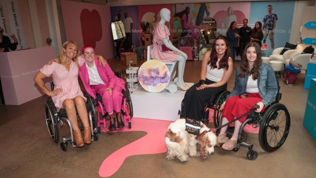 Sophie Morgan mit einer Gruppe von Rollstuhlfahrern vor der ersten Rollstuhl-Schaufensterpuppe.