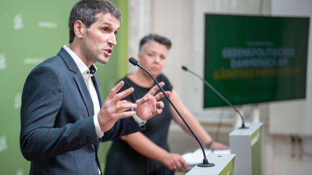 Lukas Hammer und Olga Voglauer stehen an Rednerpult