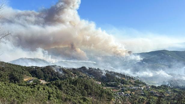 Smoke from a wildfire rises over the hills near the village of Canelas