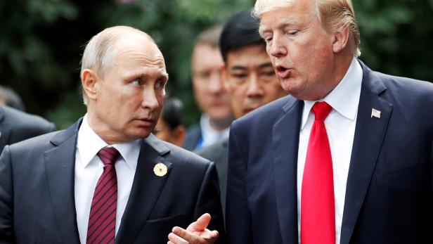 FILE PHOTO: U.S. President Donald Trump and Russia's President Vladimir Putin talk during the family photo session at the APEC Summit in Danang, Vietnam