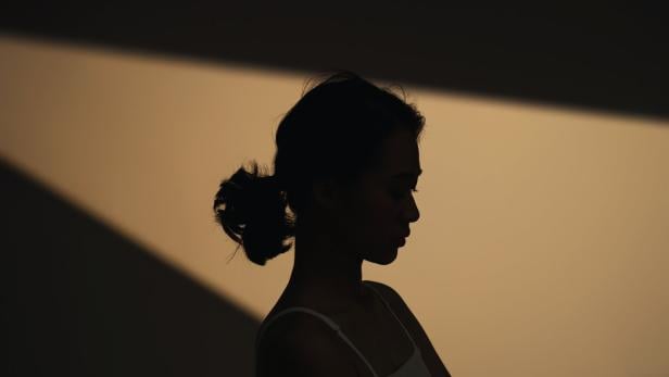 Schatten-Foto einer jungen, nachdenklichen Frau.