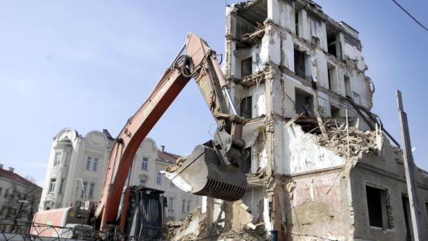 Ein Bagger reißt ein beschädigtes Gebäude ab.