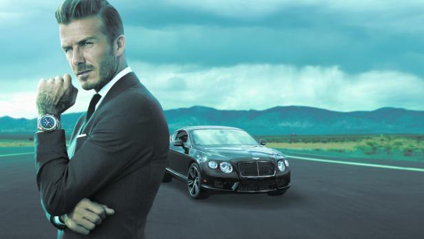 David Beckham posiert vor einem schwarzen Bentley auf einer Landebahn.