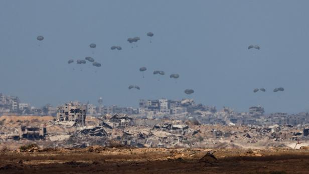 An aircraft drops humanitarian aid packages over the Gaza Strip, as seen from Israel An aircraft drops humanitarian aid packages over the Gaza Strip, as seen from Israel