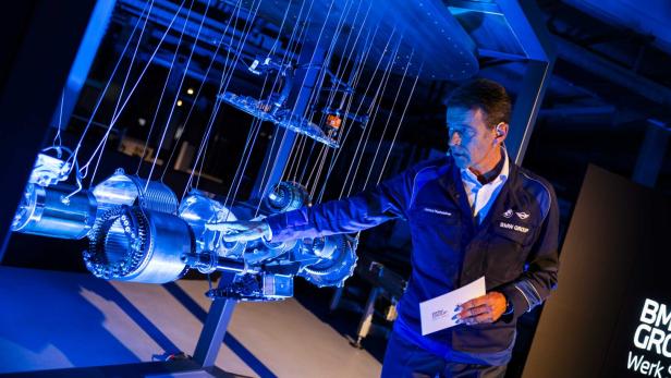 46-217570313 Mann zeigt neuen E-Motor