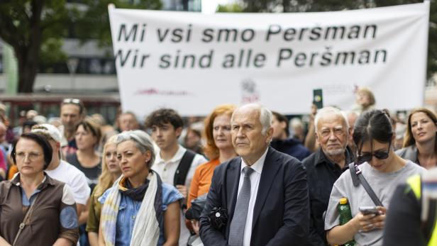 DEMONSTRATION "VOLLE AUFKLÄRUNG DES EINSATZES VOM 27. JULI 2025 AM PERŠMANHOF" Eine Menschenmenge steht hinter einem Banner mit der Aufschrift „Mi vsi smo Peršman / Wir sind alle Peršman“.