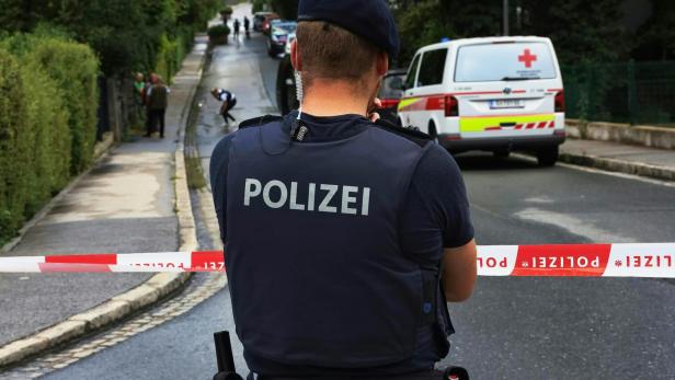 Polizist vor Polizeiabsperrung auf Straße