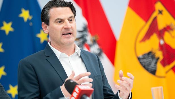 Christoph Zarits vor Flaggen am Rednerpult