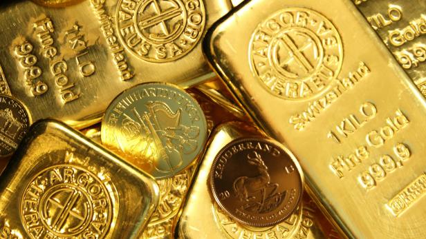 Mehrere Goldbaren und Goldmünzen sind abgebildet.