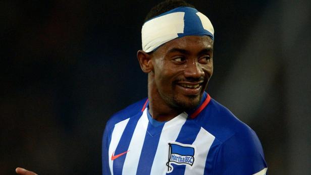 Ein lächelnder Fußballspieler von Hertha BSC mit einem Turban auf dem Kopf.