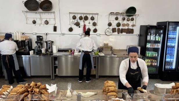 Eine Frau bereitet Cannoli in einer Konditorei zu.