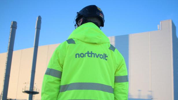 Arbeiter mit Sicherheitsweste und Helm vor der  Northvolt Ett Fabrik in Skelleftea, Schweden.