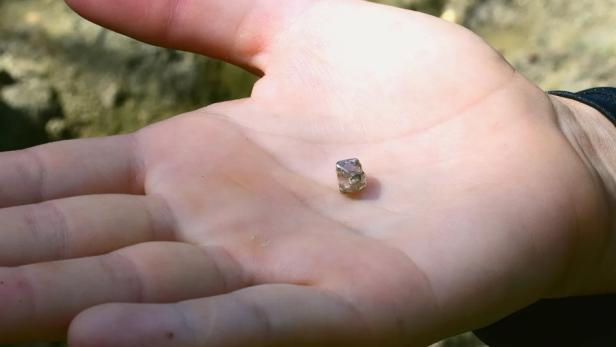 Junge Frau findet Diamanten in der Erde.